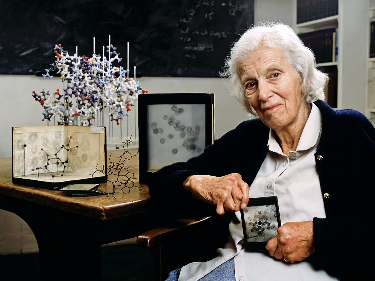 Dorothy Hodgkin sits in front of some chemistry equipment and holds a chemistry-related award Dorothy Hodgkin sits in front of some chemistry equipment and holds a chemistry-related award