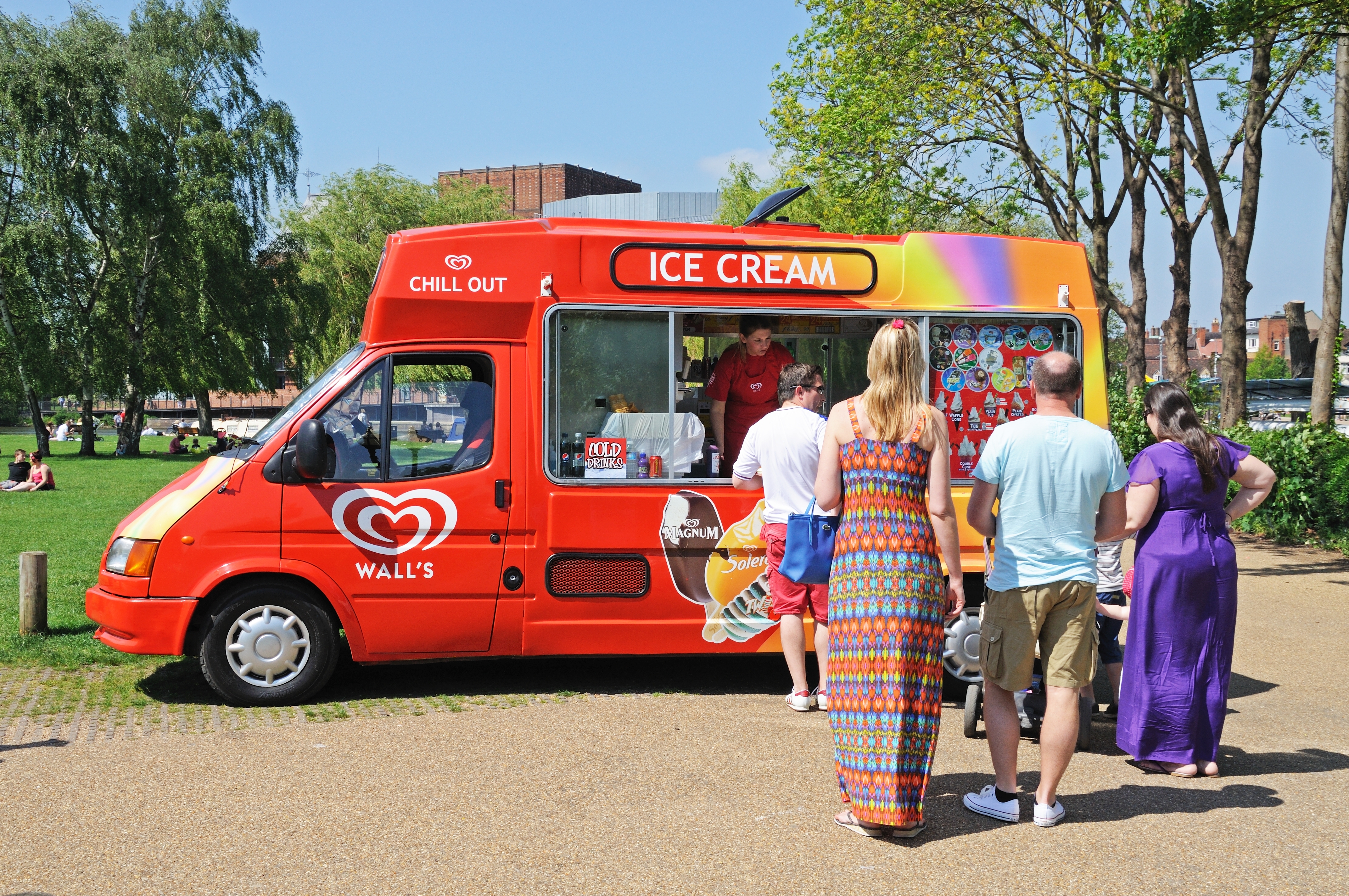 Customers queue up to buy from an ice cream van on a sunny day Customers queue up to buy from an ice cream van on a sunny day
