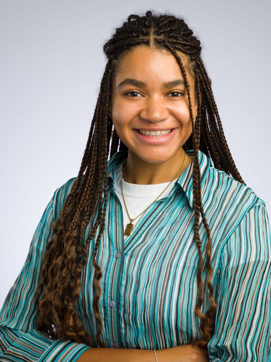 Christina Dumitriu Jackson with braided hair and green striped shirt, smiling for the camera