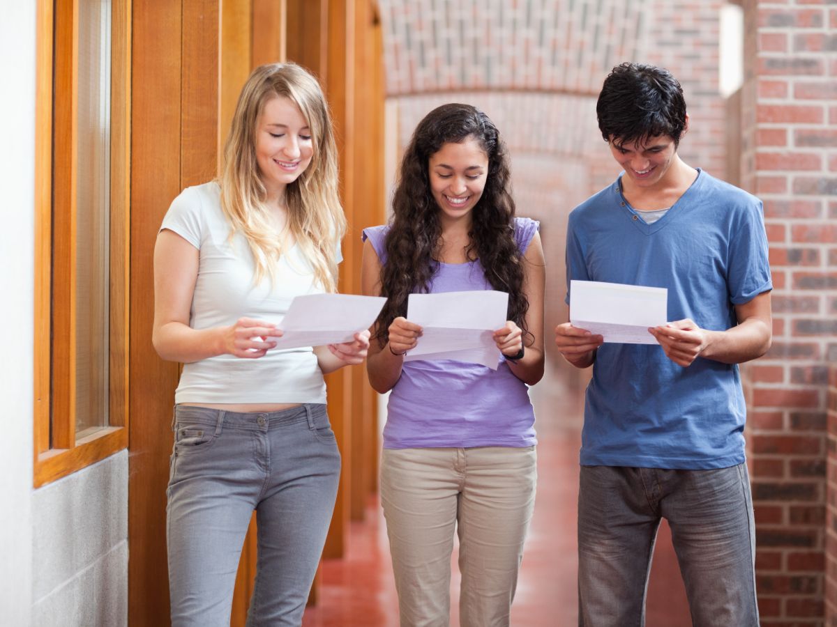 Three students opening exam results