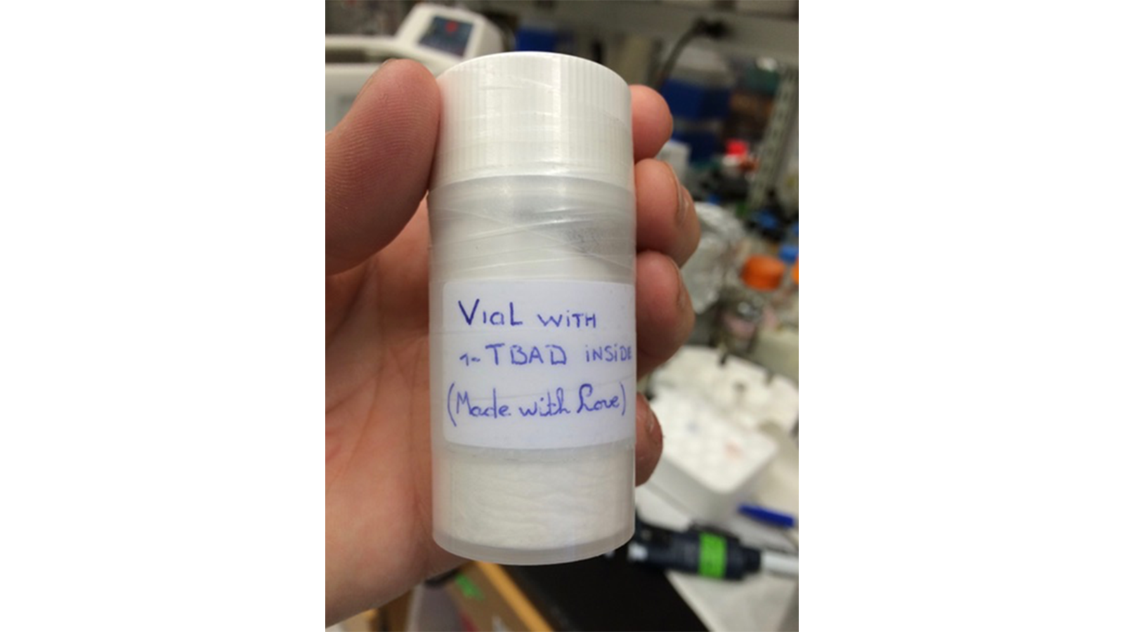 The Lipidomics Team member holding a vial of white product