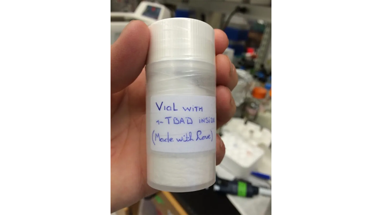 The Lipidomics Team member holding a vial of white product