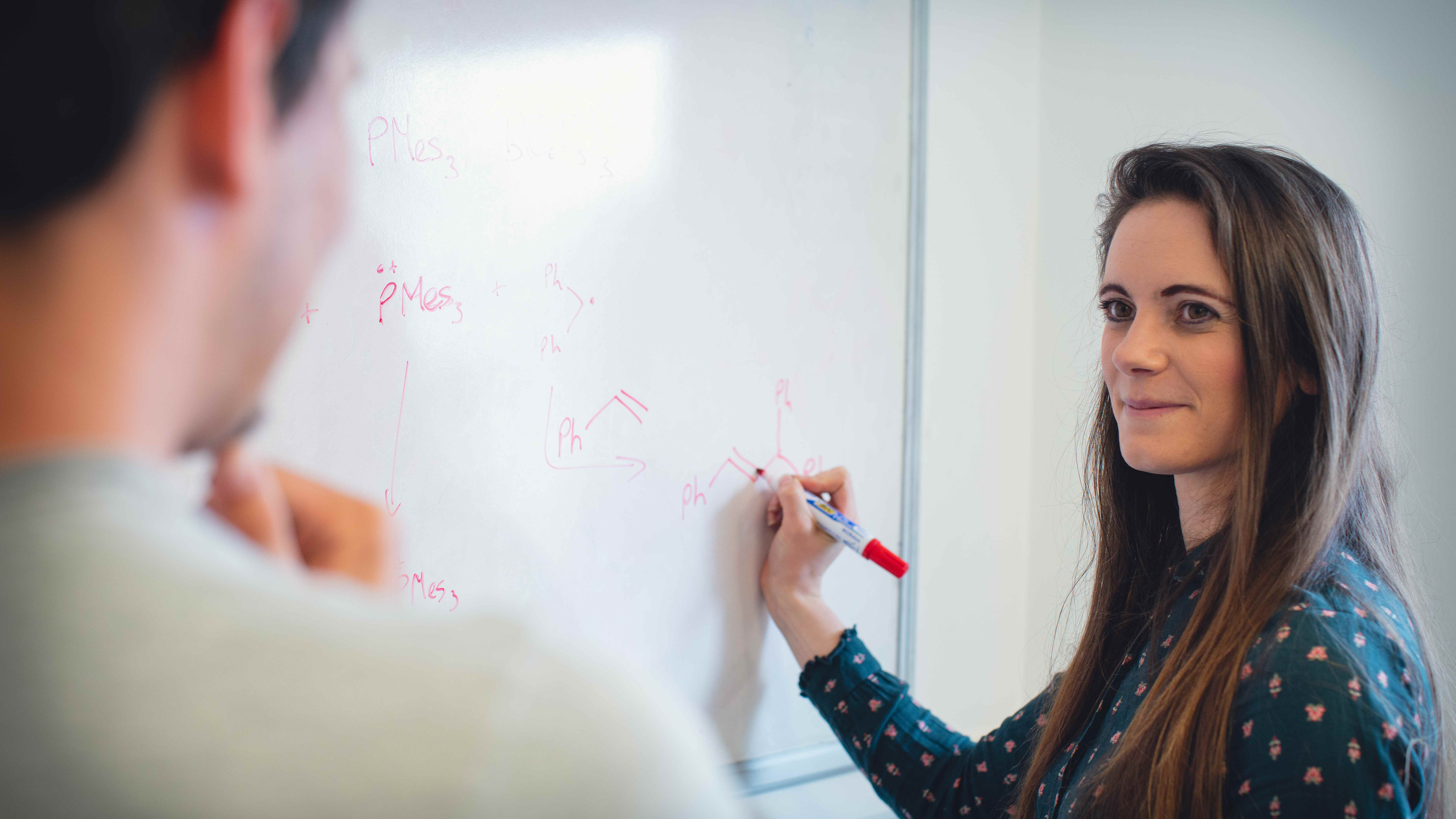 Professor Rebecca Melen writing on a whiteboard