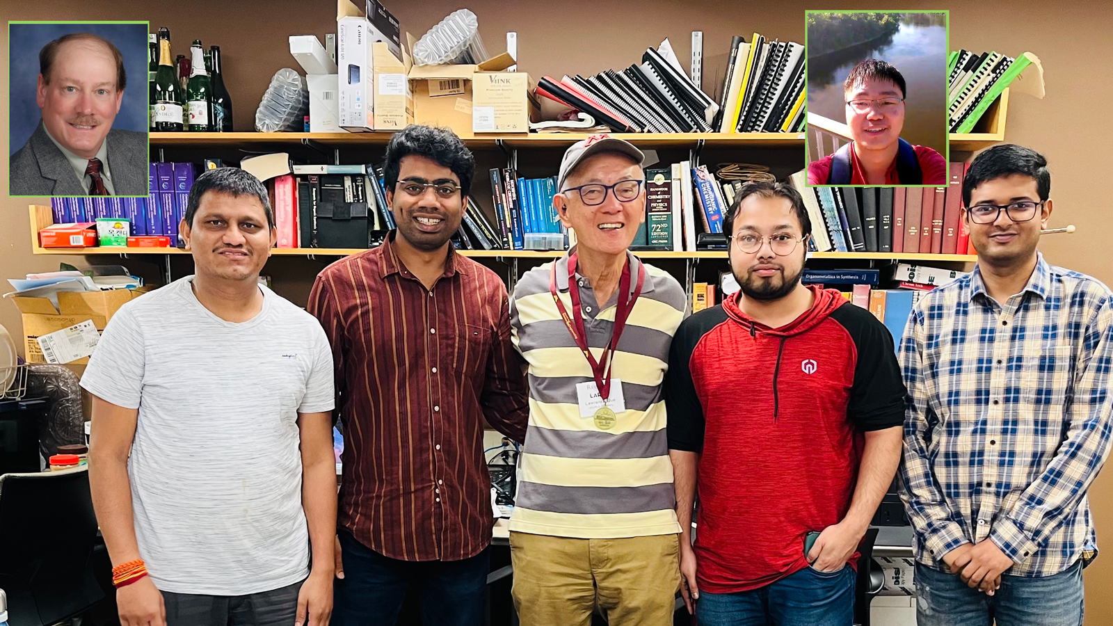 Nonheme iron-oxo oxidants team members standing in front of a shelf with books, smiling for camera