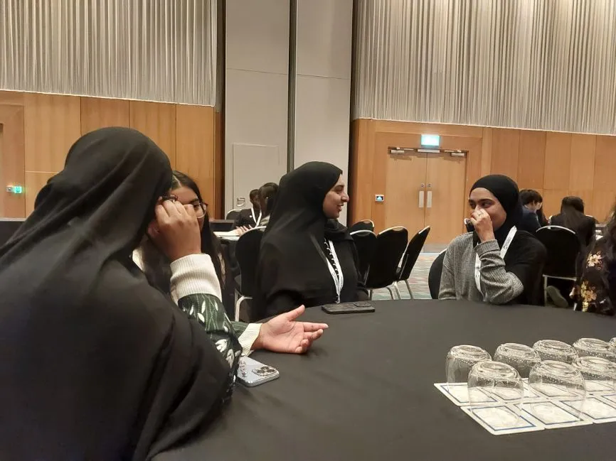 A group of women sit around a table in discussion during a group exercise