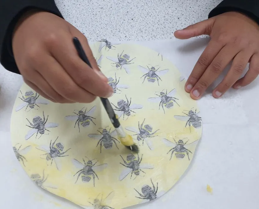 A student makes a beeswax food wrapper.