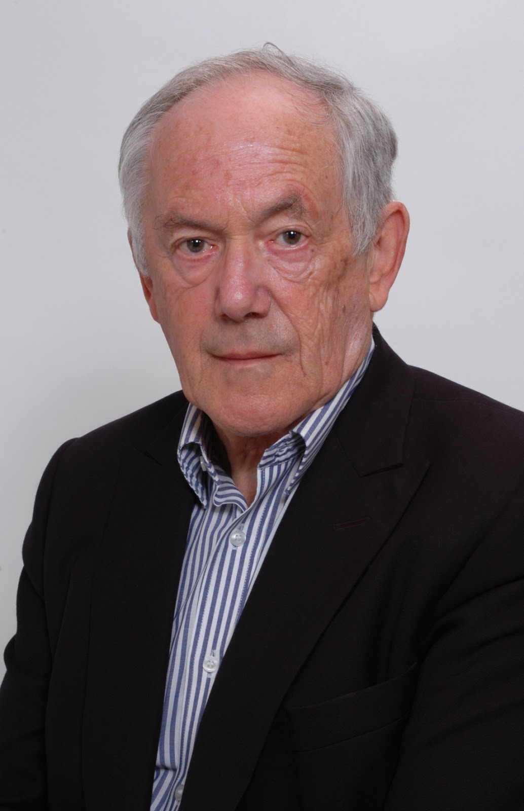 Peter Atkins in a black suit and a blue-and-white-striped shirt Peter Atkins in a black suit and a blue-and-white-striped shirt