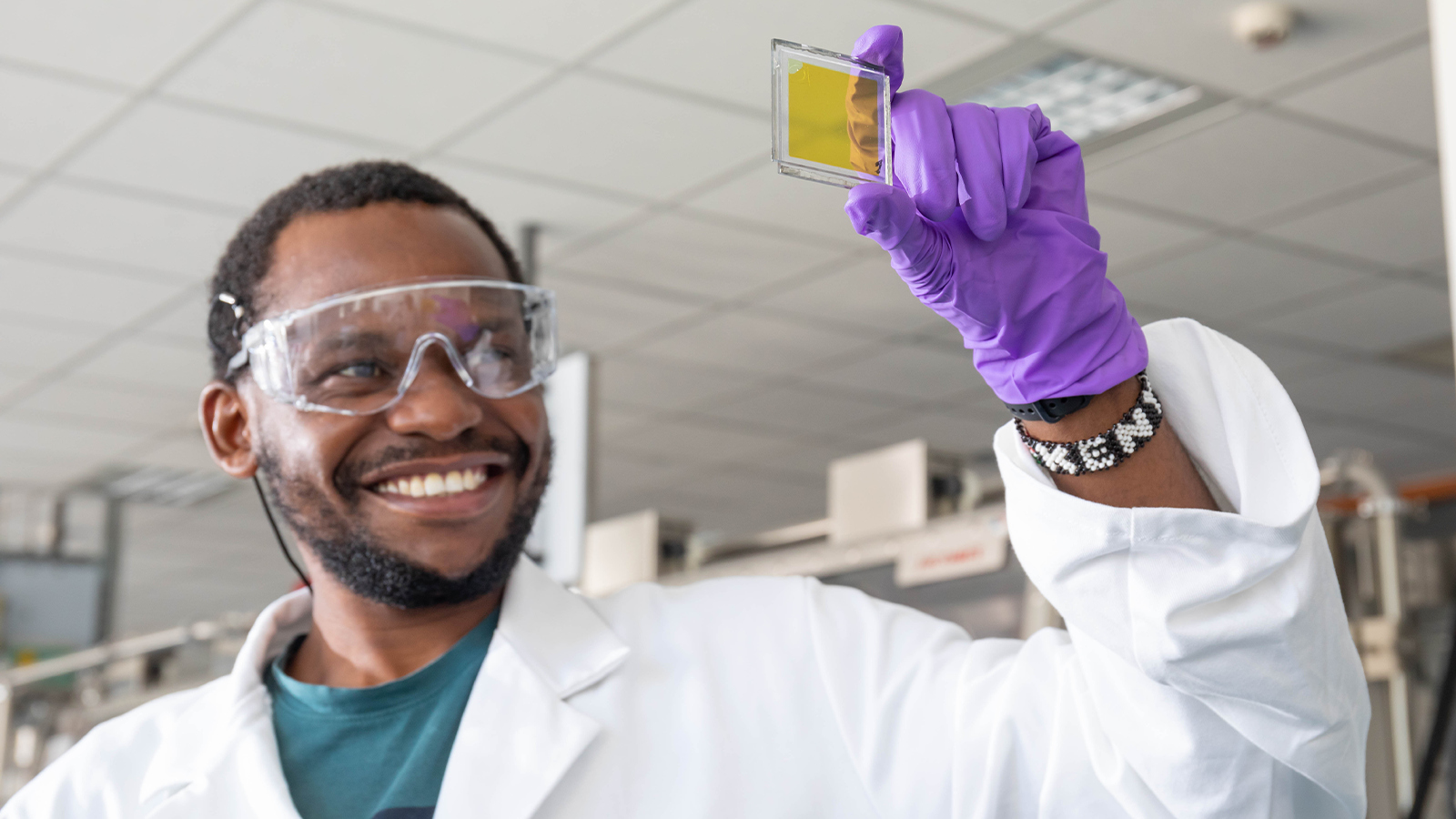 a man wearing gloves and holding a slide