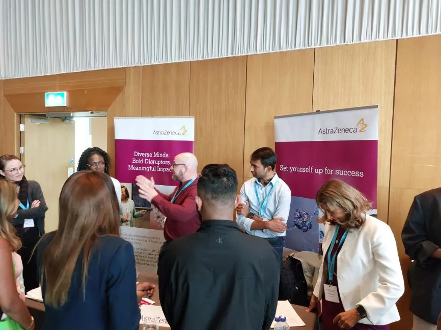 Several programme participants visit the stall of AstraZeneca